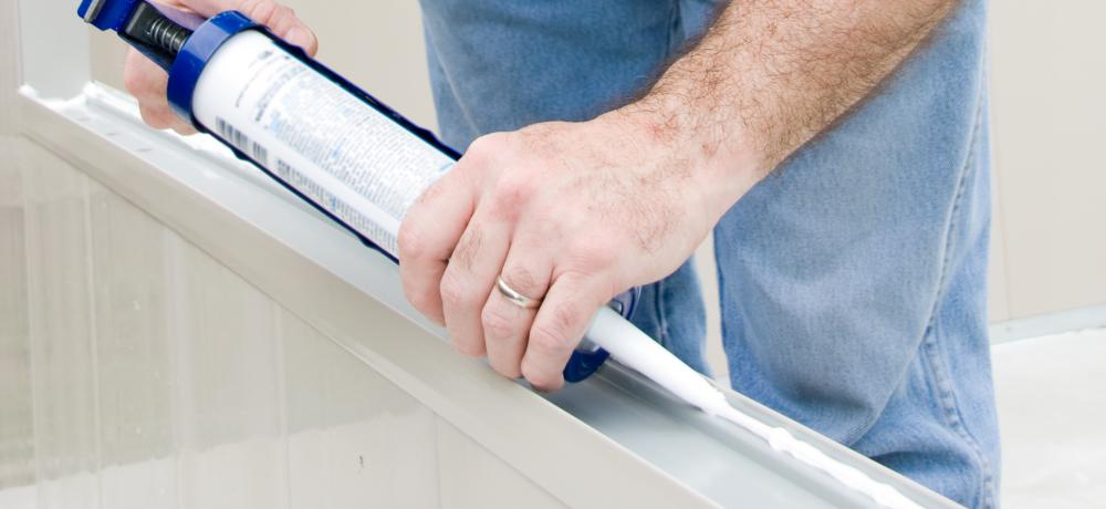 A person applying rubber caulk.