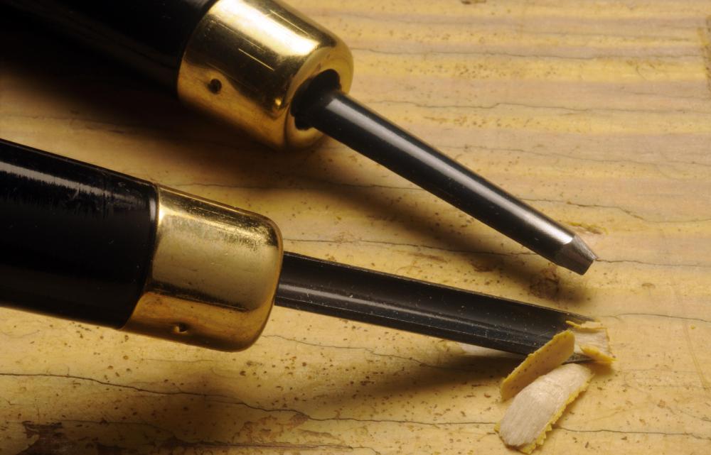 Chisel and poker tools are used to create decorative burn marks in wood.