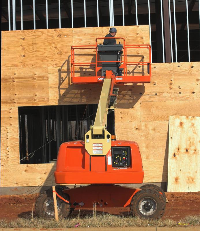 Plywood sheets being attached to the side of a building.