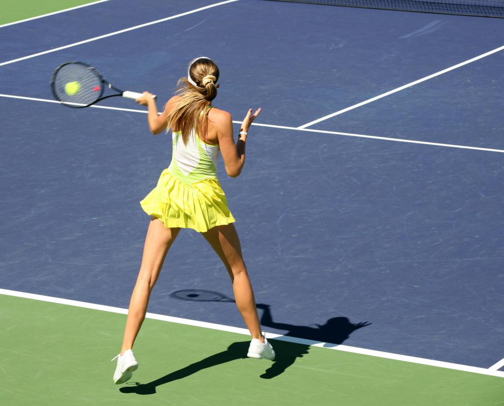 An apartment complex's common garden area may include amenities like a tennis court.