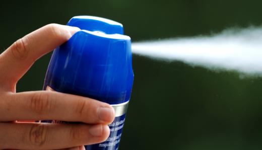 A person using citronella spray.