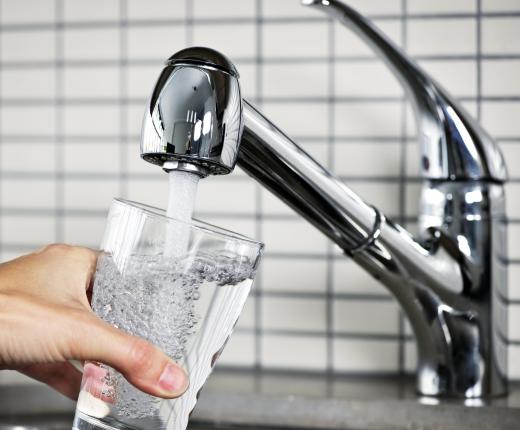 Filling a glass with tap water from a faucet.