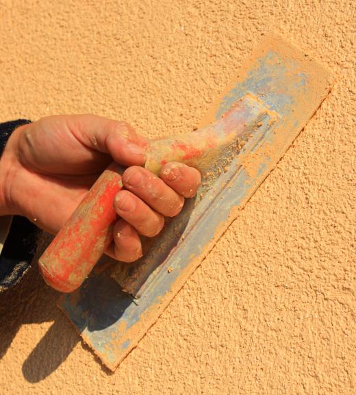 A person finishing concrete with a finishing trowel.