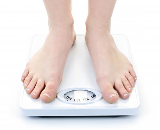 With a mechanical bathroom scale, a dial turns to display a person's weight.