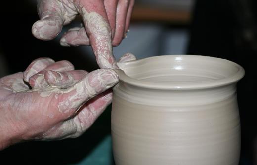 The creation of pottery begins with the mixing of clay.