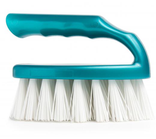 Use a scrub brush to clean the rim around a washing machine's door.