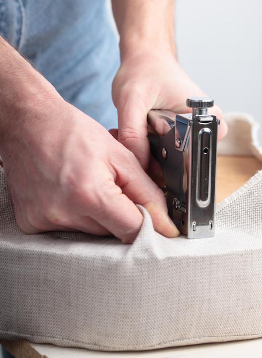 Heavy-duty staples are used to install upholstery material to a base.