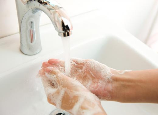 Washing hands with soap and tap water.